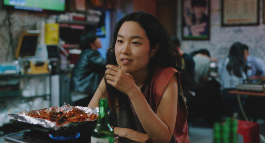 Freddie (Park Ji-Min) sitting drinking at a bar.